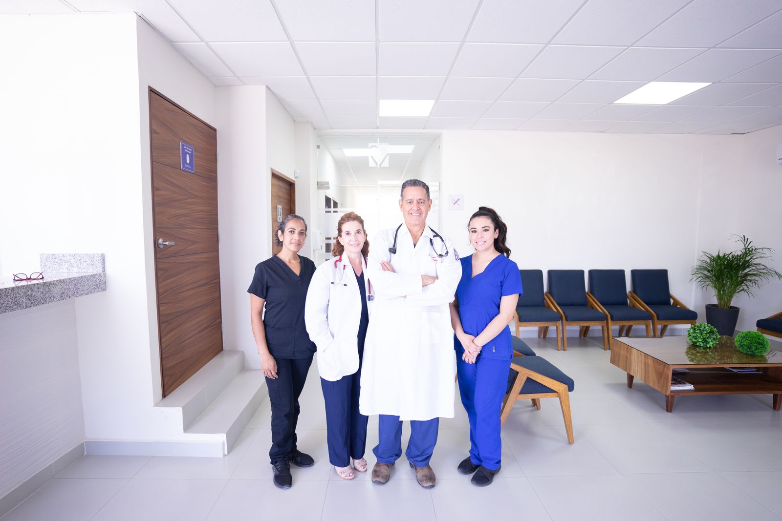Clinic staff talking together in a bright corridor